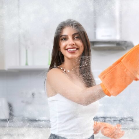 smiling-woman-washing-window-with-rag-min (1)